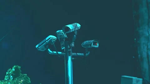 Four CCTV cameras are positioned high on a metal pole, providing full 360-degree Stock Footage 308880451