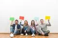 The four cheerful friends hold dialog signs on the white background Photo