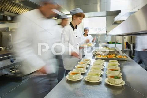 Four chefs working in a modern kitchen Stock-Fotos