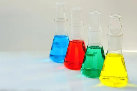 Four chemical flasks with a multi-colored liquid are used in the analytical l Photos