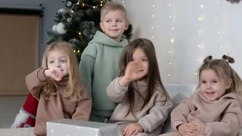 Four children showing bye-bye near Christmas tree Stock Footage 145747232