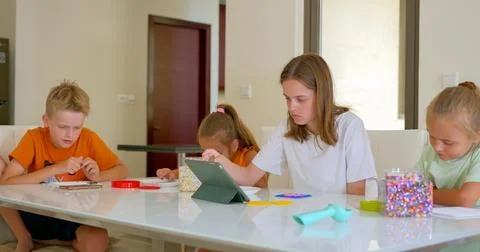 Four children, of variable age putting the mosaic together on the table Stock-Fotos