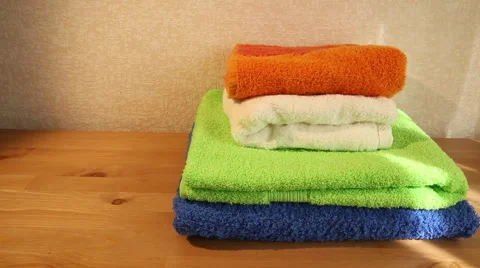 Four clean towels folded on a table panning Stock Footage 49684617