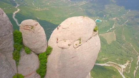 Four climbers climbed a huge boulder of Montserrat mountain in Spain. Stock Footage 129562847
