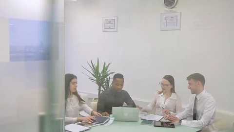 Four colleagues work on the report in bright odern co-working room. Video stock 85460179