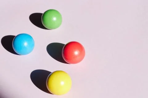 Four colored balls on a light background with hard shadows. abstract backgrou Stock Photos