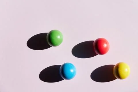 Four colored balls on a light background with hard shadows. abstract backgrou Stock Photos