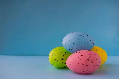 Four colored Easter eggs on a light blue background Stock Photos