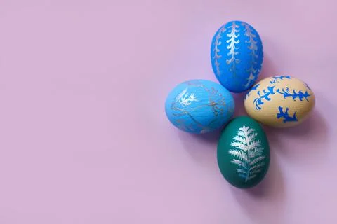 Four colored easter eggs on a pink background top view. horizontal image with Stock Photos