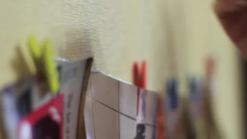 Four colored paper square frame on a clothesline and clothespins in the hands of Stock Footage 134419098