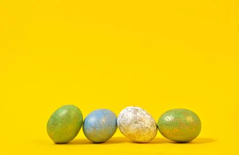 Four Colorful Easter eggs on a yellow background in the style of minimalism.  Foto stock