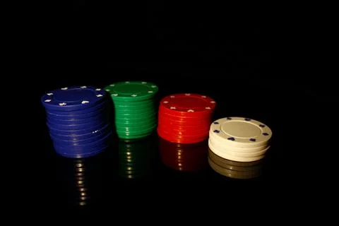 Four colors of casino chips stack : blue, green, red white isolated on black Stock Photos