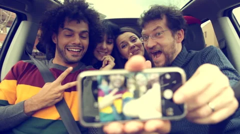 Four cool people taking selfie in car Stock Footage