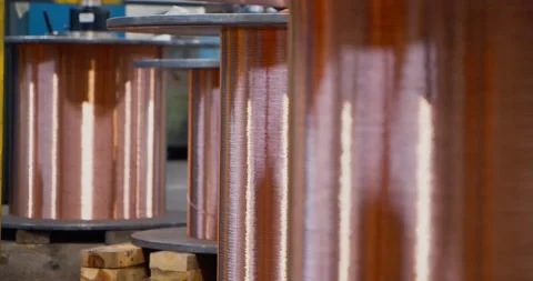 Four copper bobbins unwinding in a cable factory, shallow focus close up Vídeos de archivo 154798639