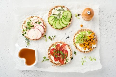 Four crispy buckwheat bread with cream cheese, radish, tomato, chickpea, cucu Stock Photos