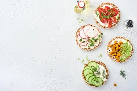 Four crispy buckwheat bread with cream cheese, radish, tomato, chickpea, cucu Stock Photos