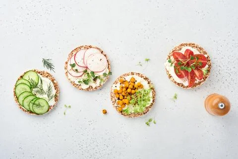 Four crispy buckwheat bread with cream cheese, radish, tomato, chickpea, cucu Stock Photos