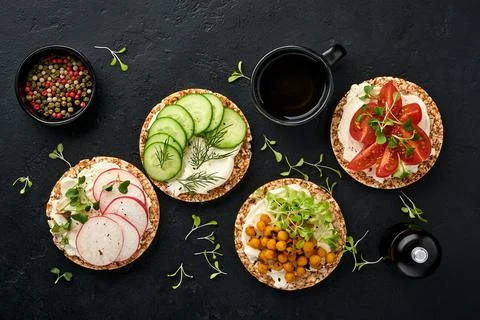 Four crispy buckwheat bread with cream cheese, radish, tomato, chickpea, cucu Stock Photos