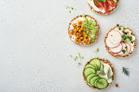 Four crispy buckwheat bread with cream cheese, radish, tomato, chickpea, cucu Stock Photos
