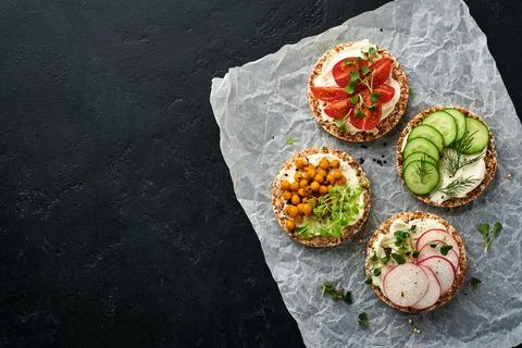 Four crispy buckwheat bread with cream cheese, radish, tomato, chickpea, cucu Stock Photos