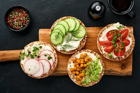 Four crispy buckwheat bread with cream cheese, radish, tomato, chickpea, cucu Stock Photos