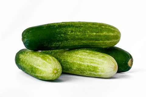 Four cucumbers for greens, in a stack composition, isolated on a white backgr Stock Photos