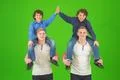 The four cute brothers stand on the green background Photo