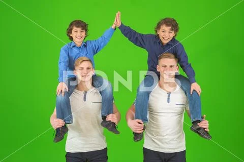 The four cute brothers stand on the green background Stock Photos