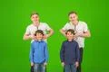 The four cute brothers stand on the green background Photo