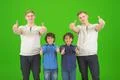 The four cute brothers stand on the green background and thumb up Photo