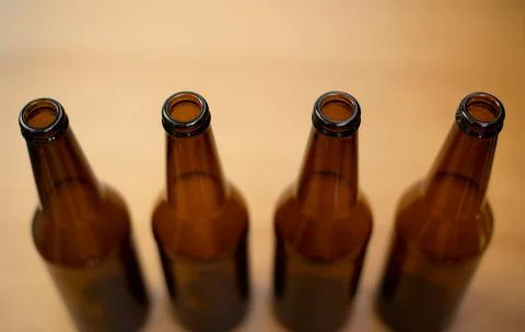 Four dark empty beer bottles. Stock Photos