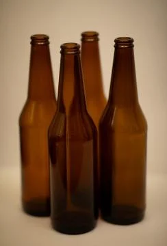 Four dark empty beer bottles Stock Photos