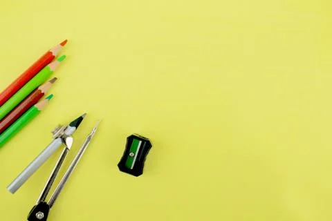 Four different colored pencil crayons,a pencil attached to a pencil compass a Stock Photos
