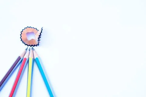 Four different colored pencil pointing at a pencil shaving in a quarter circl Stock Photos