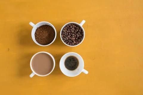 Four different cups on a yellow background Stock Photos