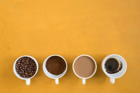 Four different cups on a yellow background Stock Photos