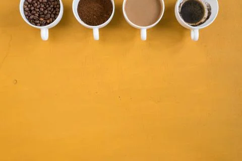Four different cups on a yellow background Stock Photos