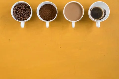 Four different cups on a yellow background Stock Photos