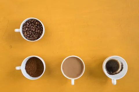 Four different cups on a yellow background Stock Photos