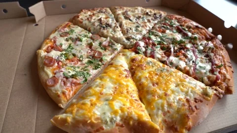 Four different types of pizza in a cardboard box, ready to serve, with Stock Footage 306639032