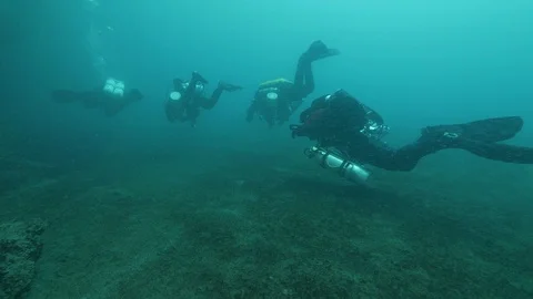 Four divers swim on the bottom of the lake, San Domenico lake, Italy Stock Footage 108673074