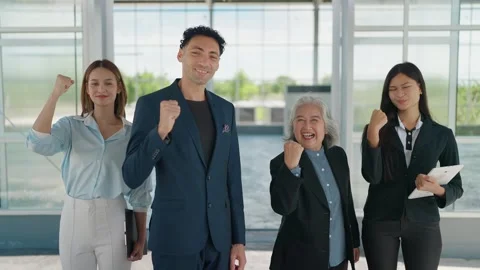 Four diverse professionals stand united, fists raised in triumph Stock Footage 344937751