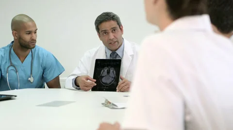 Four doctors using digital tablet in a meeting. Stock Footage 36080344