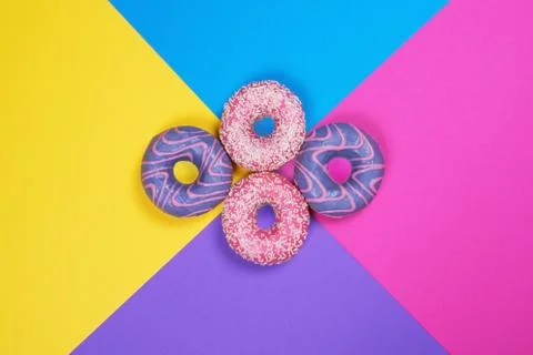 Four donuts on multi colored background. Stock Photos