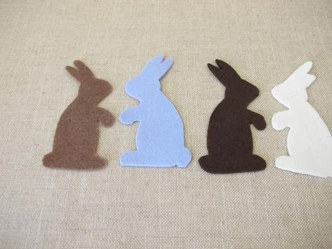 Four Easter bunnies cut out of colored felt Stock Photos