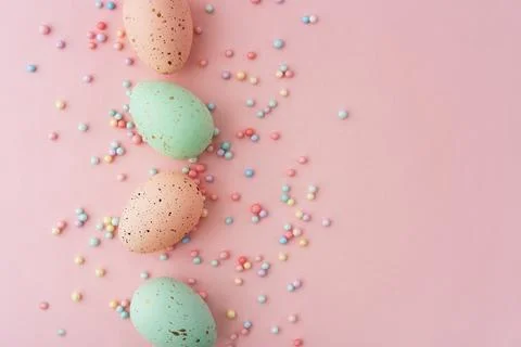 Four Easter eggs in pastel pink and green colors are artistically placed on a Stock Photos