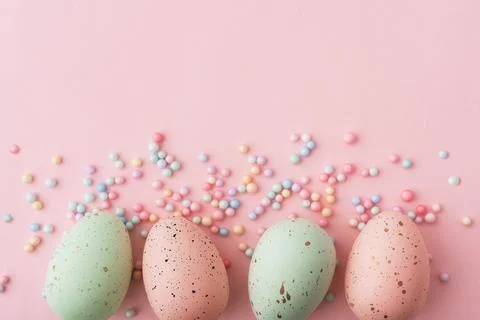 Four Easter eggs in pastel pink and green colors are artistically placed on a Stock Photos