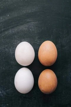 Four eggs on black background Stock Photos