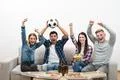 The four emotional friends on the sofa watch a football on the white backgrou Photo