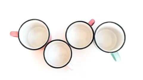 Four empty ceramic mugs on a white background. Creative concept Stock Photos